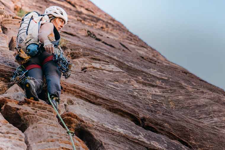 Person rock climbing on a steep cliff face