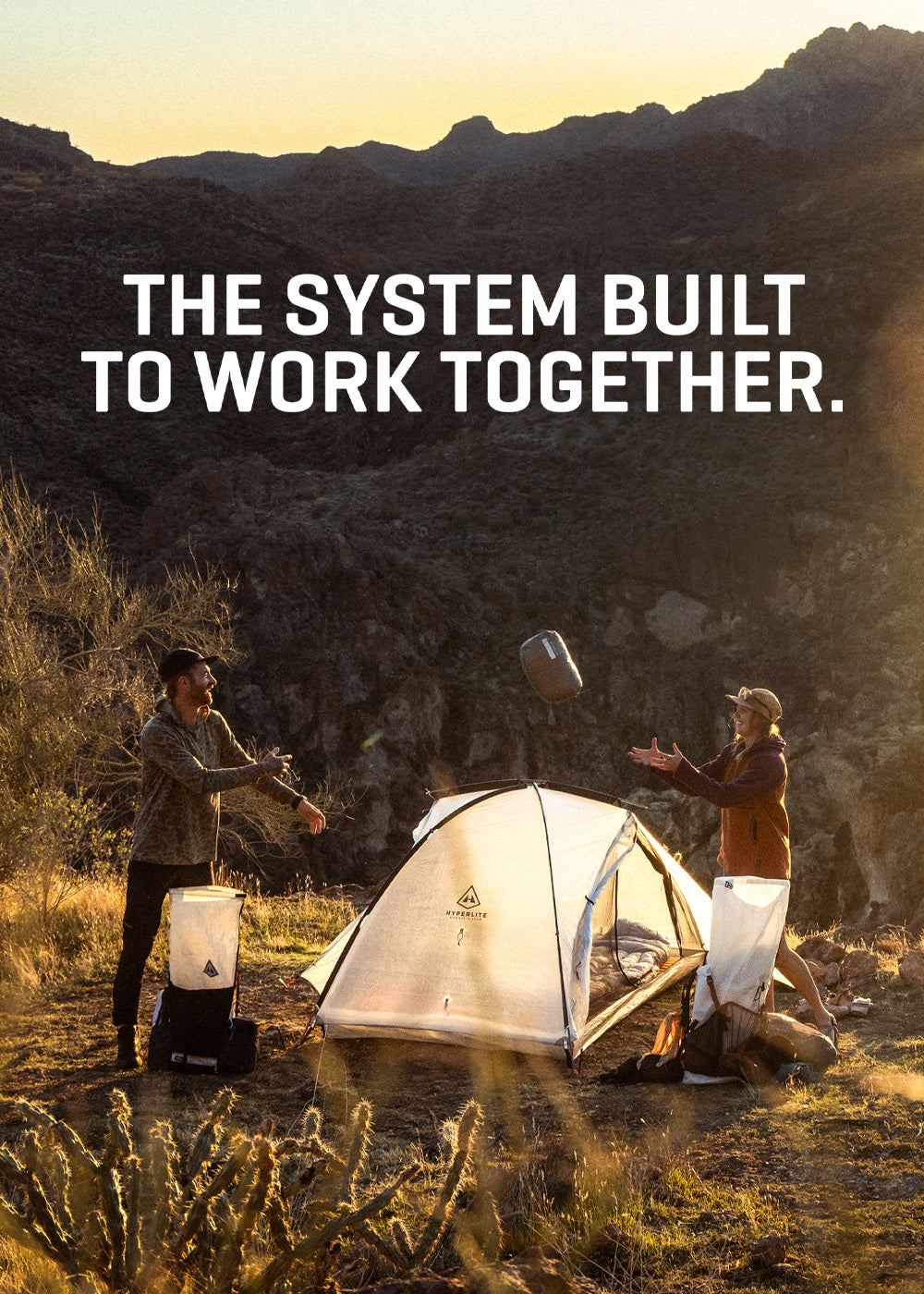 Two people setting up a tent in a desert landscape with text overlay.